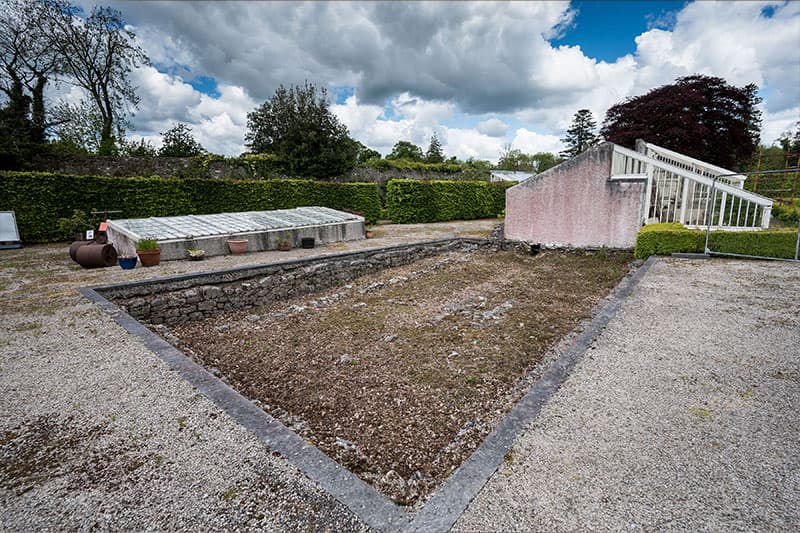 A pile of loose dirt in a garden area.