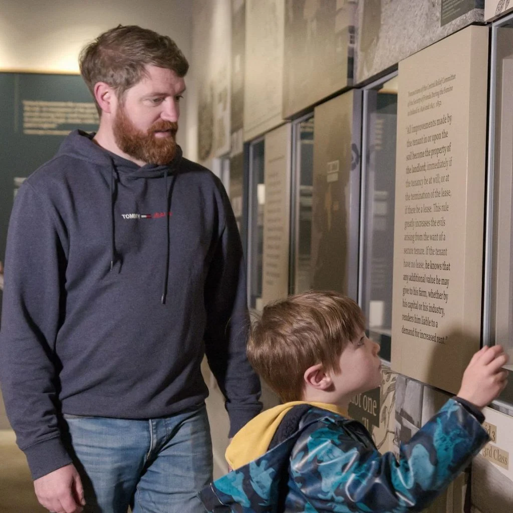 A man and child looking at an exhibition.