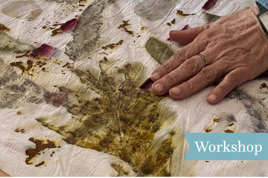 Hand creating art using paint and leaves.