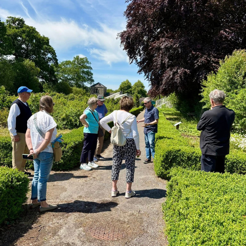 John' O Driscoll, the General Manager of Strokestown Park leading a tour in the Walled Garden surrounded by the tour group.